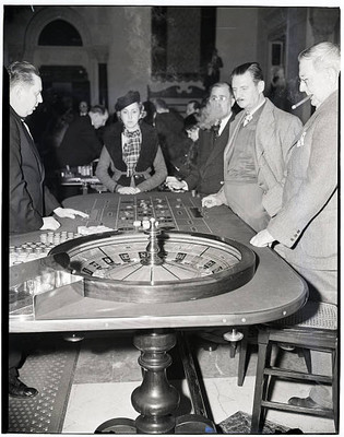 Men smoke cigars while watching the roulette wheel spin 1940 Old Photo