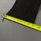Black faded bootcut jeans with frayed hems, yellow measuring tape along the waistband, showing size 8.