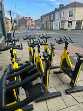 10x. Technogym Spin Bikes. Yellow/Black Upright Exercise Bike