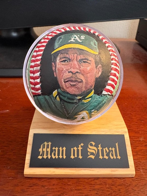 HAND PAINTED RICKEY HENDERSON BASEBALL W/BALL STAND AND NAMEPLATE.