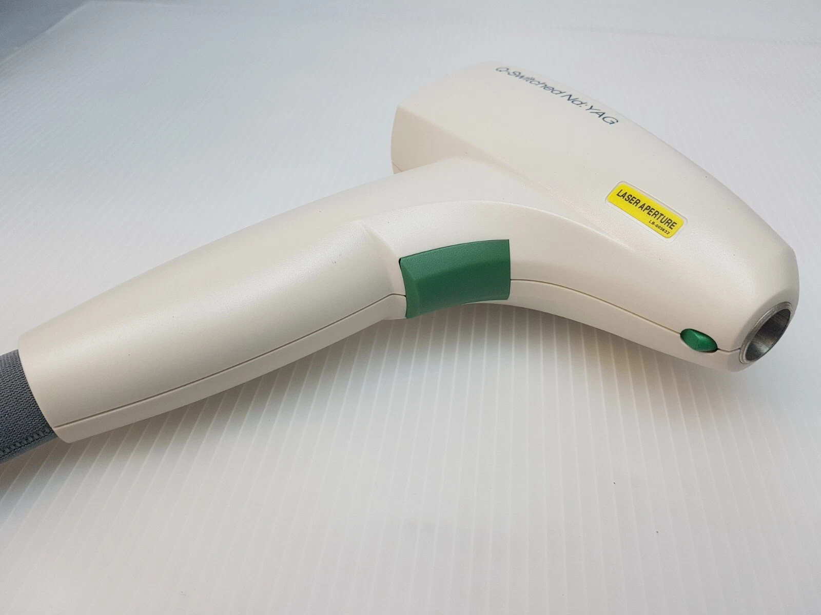 Lumenis M22 QS Nd:YAG handpiece showing aperture and green grip