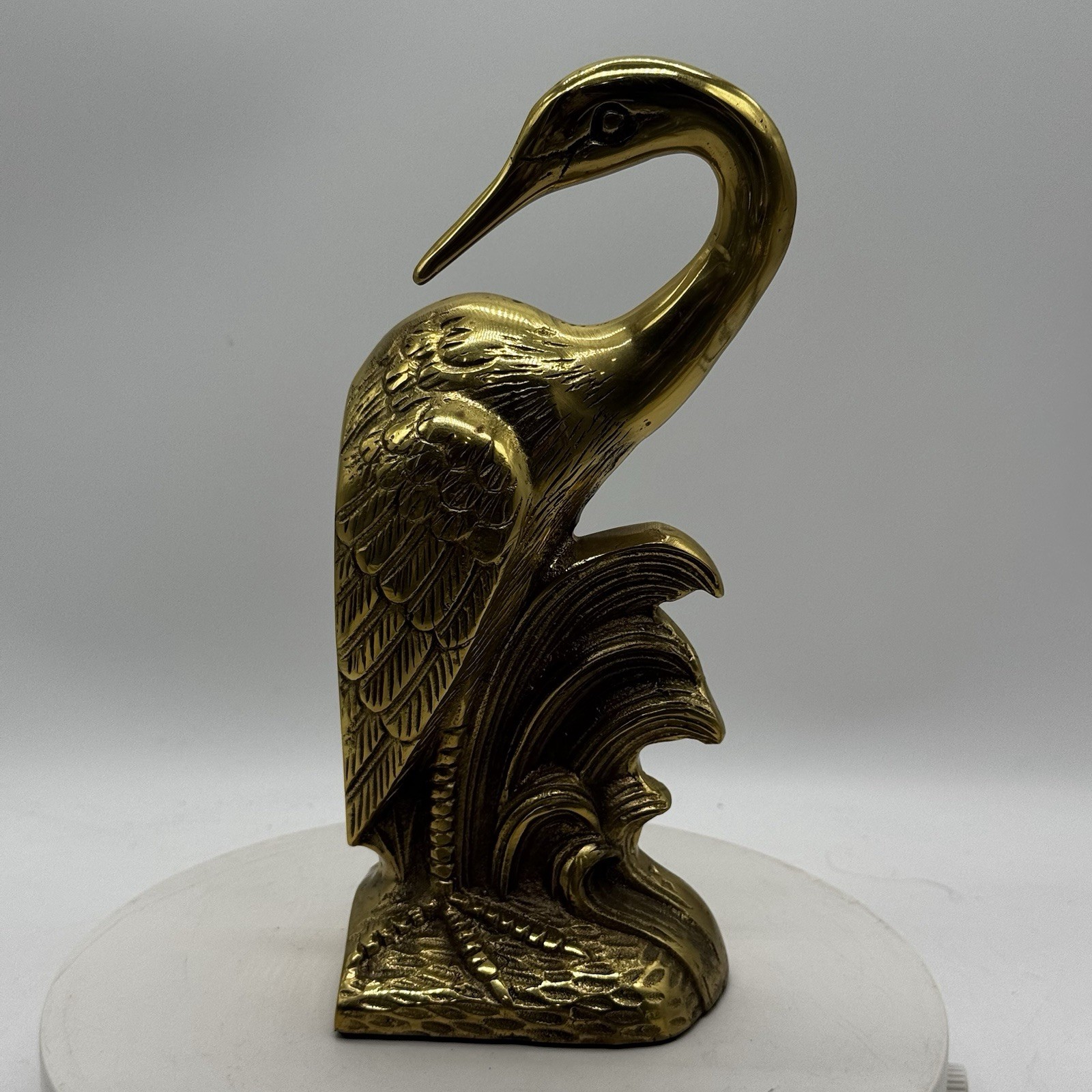 Two brass bookends cast in the shape of standing herons with long curved necks.
