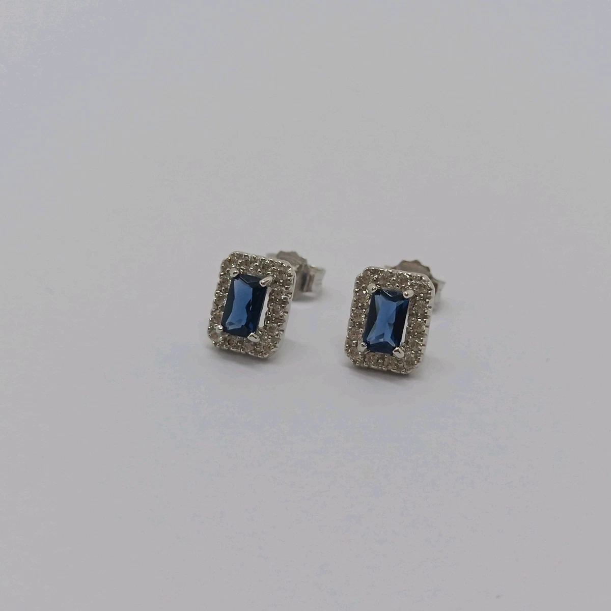 Orecchini in oro bianco 18 kt e zirconi colorati con chiusura a pressione. Peso: 1,95 g in oro 18 carati. Dimensioni: 1,20 x 1,20 cm