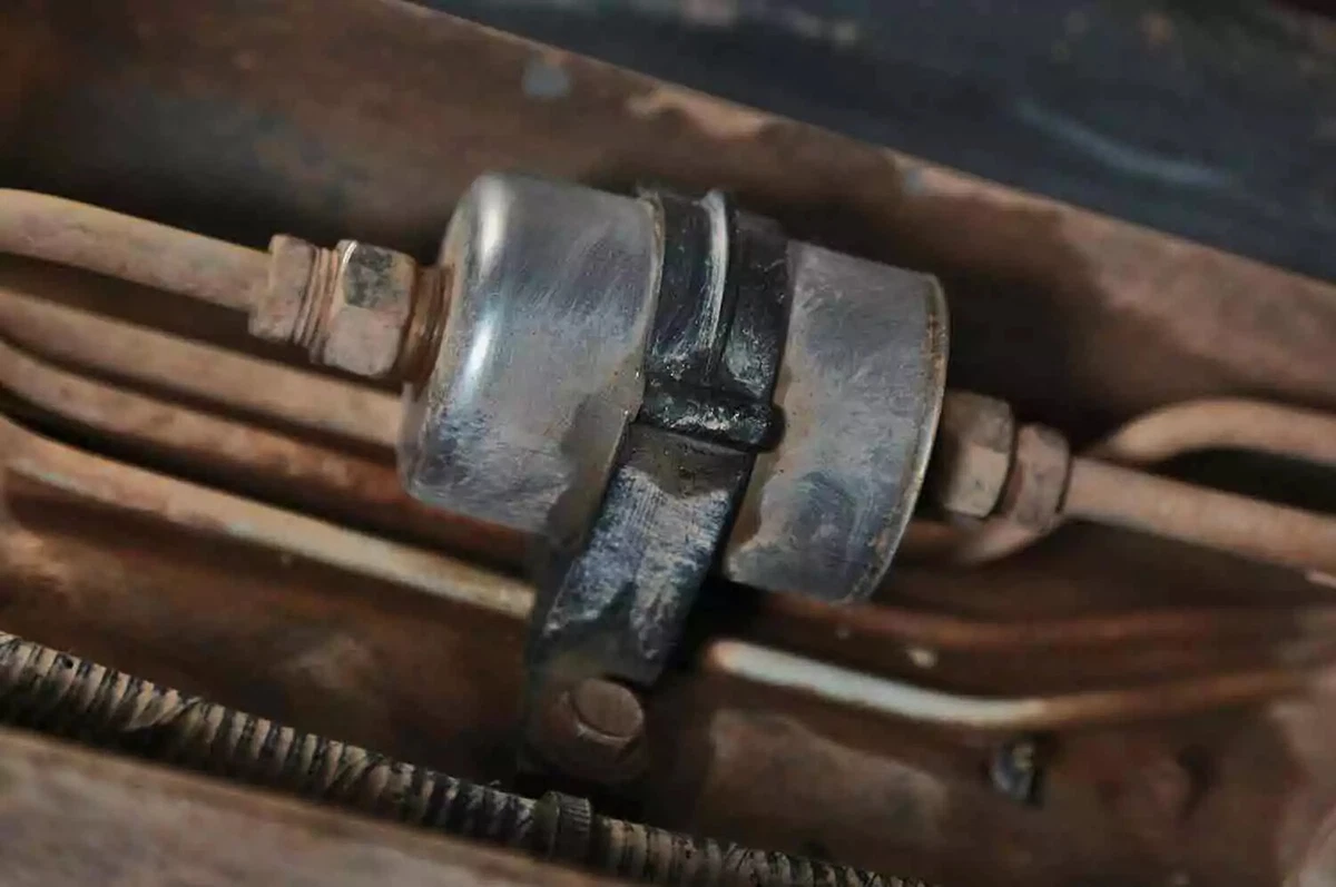 An inline fuel filter on the underside of a pickup truck.