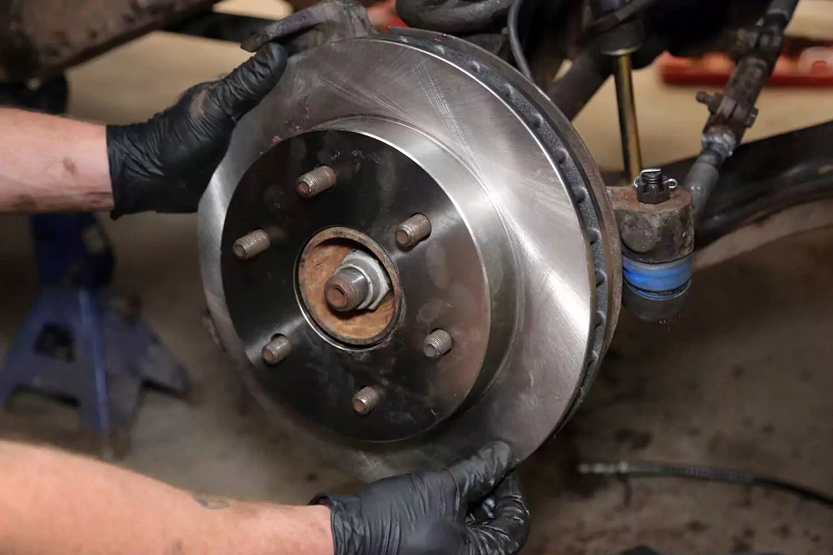 A mechanic reinstalls the brake rotor.