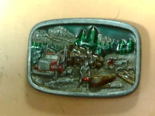 1984 vintage belt buckle by Bergamot Brass works chainsaw w/lumber truck setting