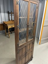 Oak-finished corner display cabinet with leaded glass doors