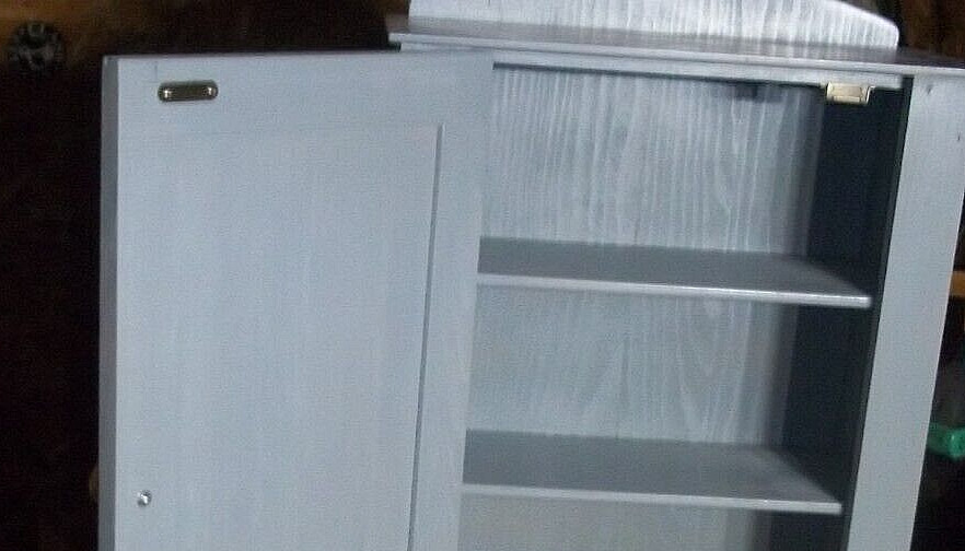 Shaker-style raised panel hanging cabinet, painted gray.