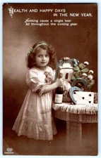 RPPC HAPPY NEW YEAR GIRL CHAMPAGNE HORSESHOES MONEYBAG HAND COLORED POSTCARD