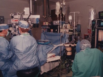 Doctors Operating Room Microscope Surgery Equipment Monitors IV Lines