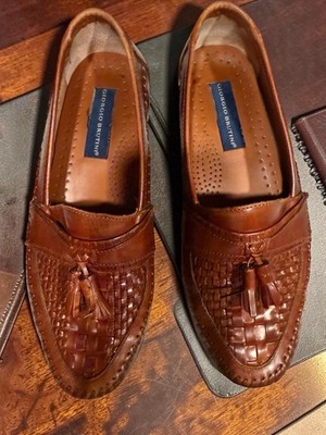 These are Giorgio Brutini brown woven leather loafers featuring a tassel detail