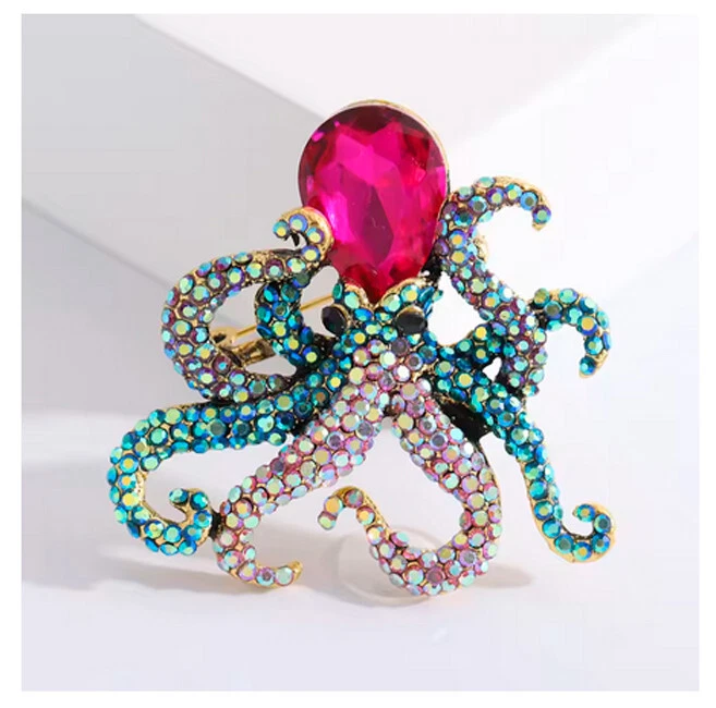 Elegante Brosche in Form eines Oktopus mit funkelnden Kristallen und rosa Stein