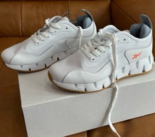 Reebok Women’s White on White Zig Dynamica G Sneakers With Orange Reebok Symbol