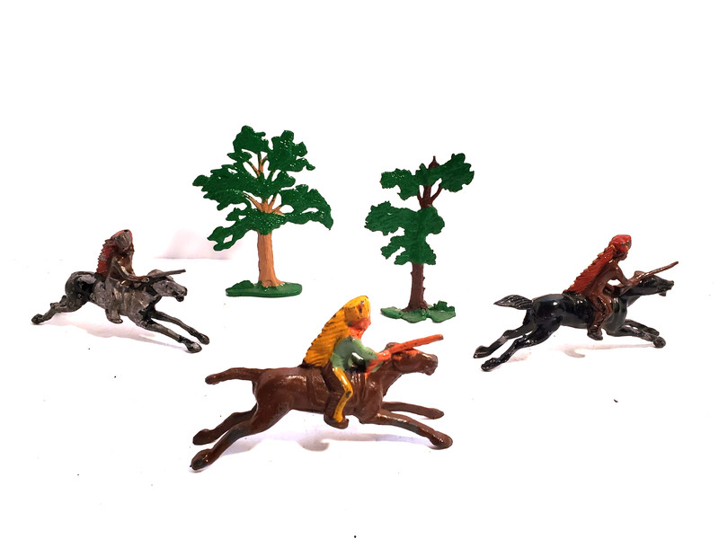 3 Toy lead American Indians w/ rifles on horses sprinting past 2 toy lead trees