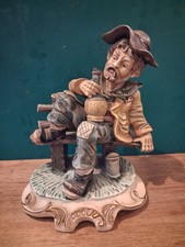 A  Large Vintage Capodimonte Style Figure Tramp on a Bench holding a Bottle