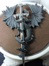 Dragon wall hanger holding a metal sword lett...