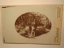 Gangkofen Neumarkt - in a forest with palm trees? standing man with hat/cab