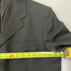 Black solid three-button blazer jacket with notch lapels, front flap pockets, and yellow measuring tape across the chest.