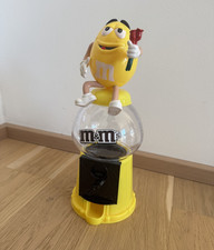Gelber M&M Spender mit Blume und Münzeinwurf