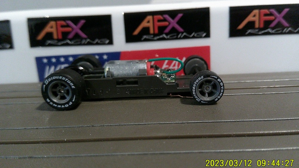 AFX Racing HO Scale Mega G+ 1.7 Narrow Chassis with Gray 5-Spoke Rims and Red Cam Letts
