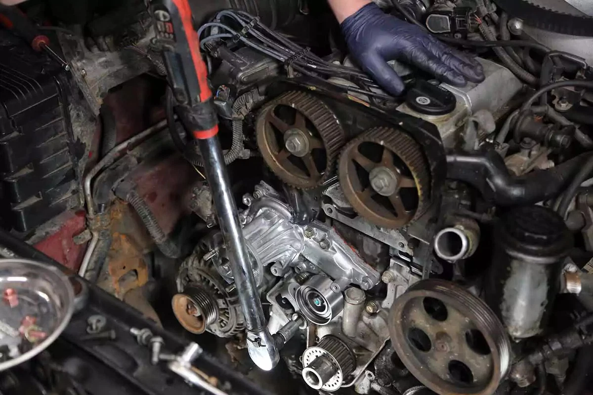 Mechanic tightening a pulley bolt with a torque wrench.