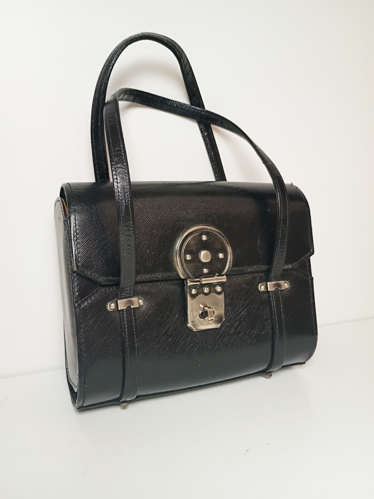 Black leather structured top-handle box bag with turn-lock closure, 1960s