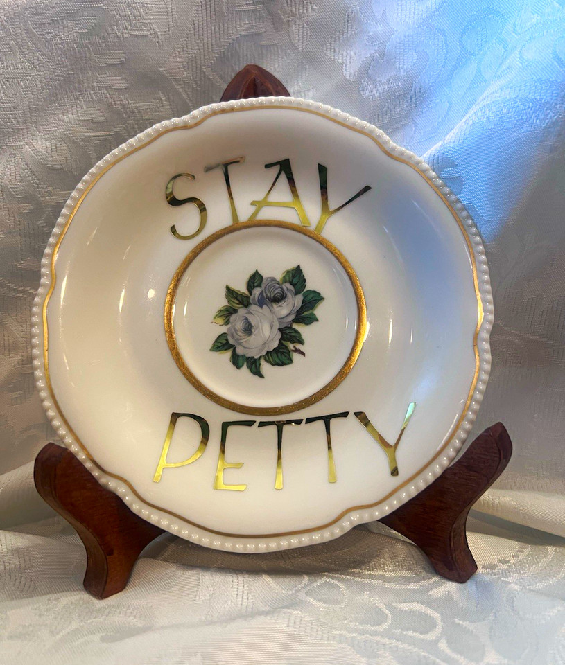 A vintage Noritake china plate hand-lettered with 'Stay Petty' — the collision of grandma's fine china and savage sass is genuinely funny and giftable.