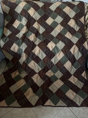 A patchwork quilt with diamond pattern in earthy tones.
