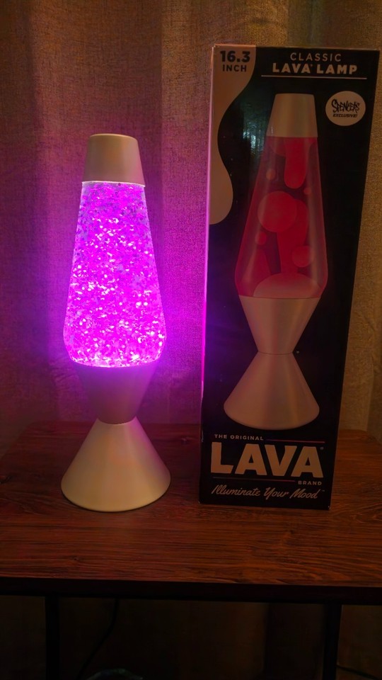A custom-made 16" opalescent lava lamp with amethyst glitter and a star-adorned white base — basically wearable galaxy energy bottled into a lamp.