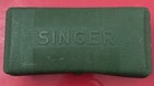 Green textured Singer box with embossed logo and “MADE IN U.S.A.” text on red background.