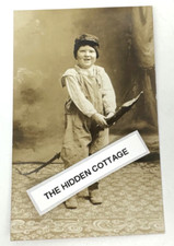 A real photo postcard (RPPC) of a kid in overalls riding a stick horse — a perfectly frozen slice of early 20th-century childhood weirdness.