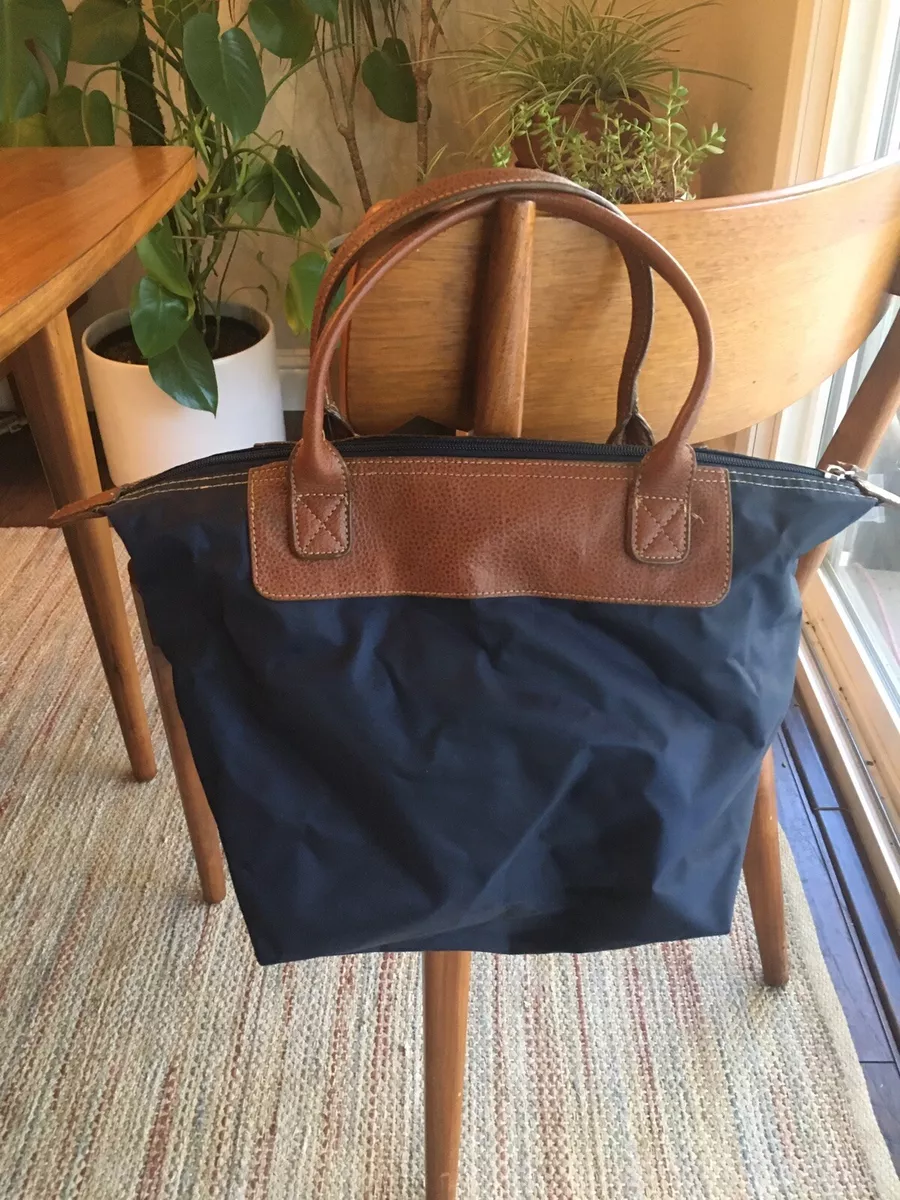 Navy tote bag store with brown handles