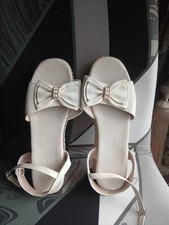 white flatform sandals with a bow and rhinestone buckle
