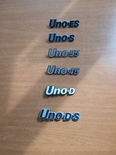 6 Badge Fiat UNO 1^ serie, vari modelli (45/55/S/ES/D/DS) in plastica.  Nuovi