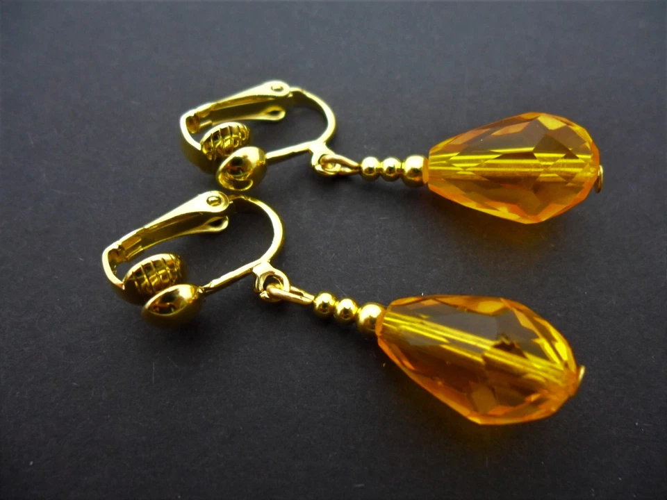 A PAIR OF ORANGE/AMBER GLASS CRYSTAL DANGLY TEARDROP CLIP ON EARRINGS. - Image 1 of 1
