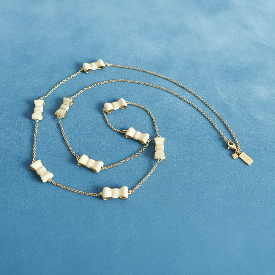 Collar Estación Kate Spade Take A Bow Esmalte Crema Tono Dorado Metal 32" Foto 2 de 4