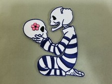 Skull Holding Skull Embroidered Iron On Patch.