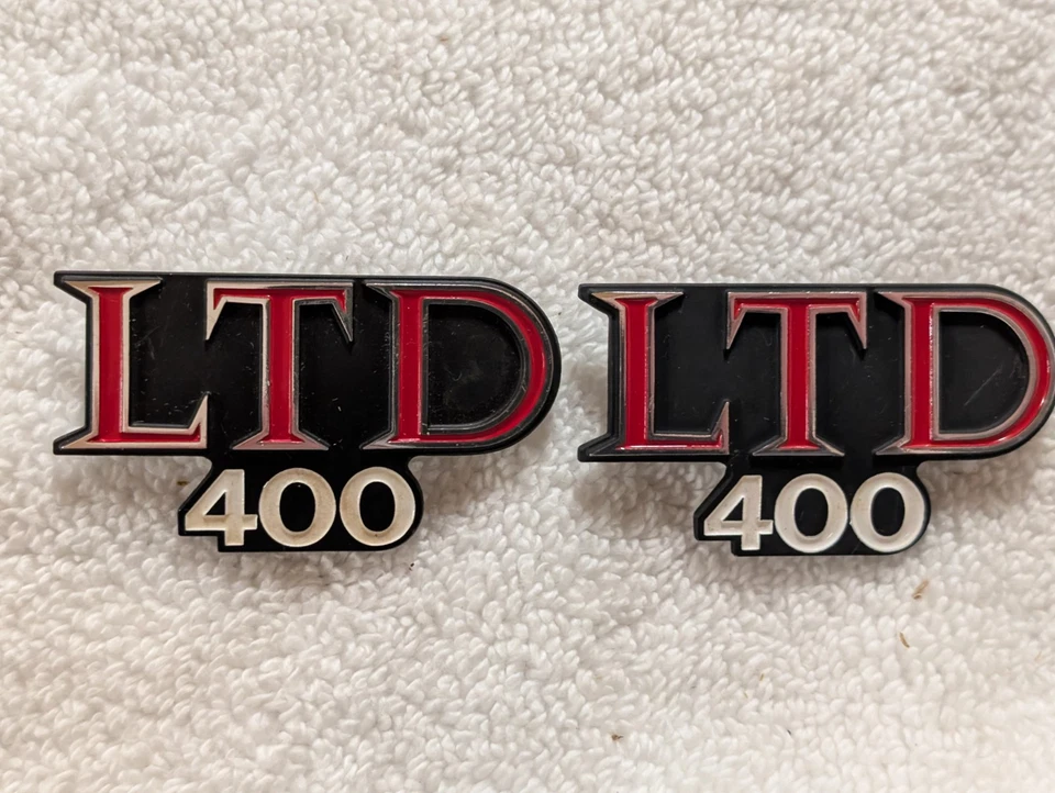 1979 KAWASAKI KZ400 LTD PAR DE EMBLEMAS/EMBLEMAS DE METAL COM TAMPA LATERAL NUNCA INSTALADOS - Imagem 2 de 4