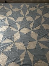 light blue and white patchwork quilt featuring a pinwheel-style design 76x84