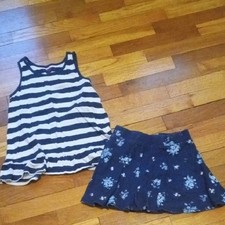 girl med navy blue white tank and flower print skort,