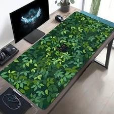 A Large Gaming Mouse Pad Featuring a Black Cat Peeking Through Green Leaves, wi