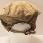 Tan suede leather newsboy cap with black adjustable strap and silver-tone buckle closure displayed on a mannequin head.