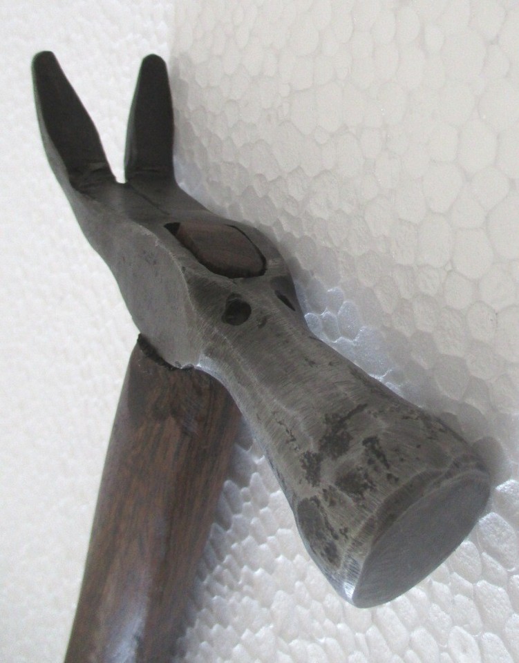 A claw hammer shaped into a figural form — part antique tool, part sculptural object, the kind of thing that stops visitors mid-sentence.