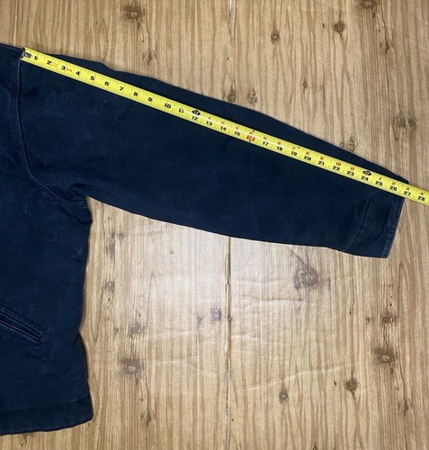 Black VTG Carhartt J01 BLK Detroit jacket with long sleeves, yellow measuring tape across the chest.