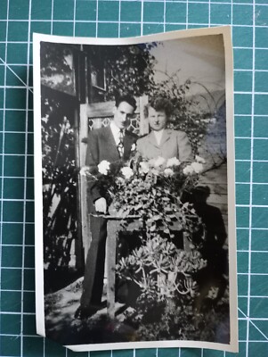VR419 Foto um 1950 junges Paar im Garten hinter weißem Rosenstrauß