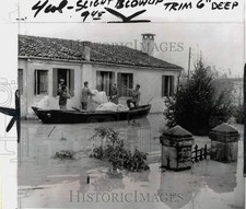1951 Press Photo Men on boats hauling furniture during a flood in Rovigo, Italy
