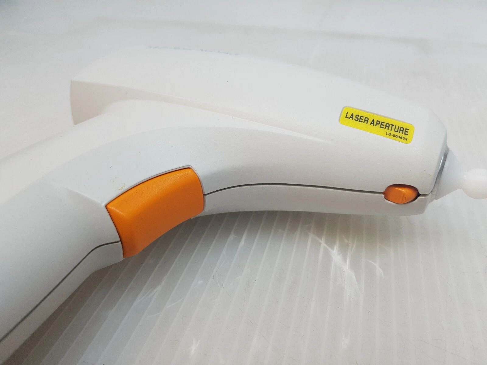 Close view of the handpiece trigger and laser aperture label