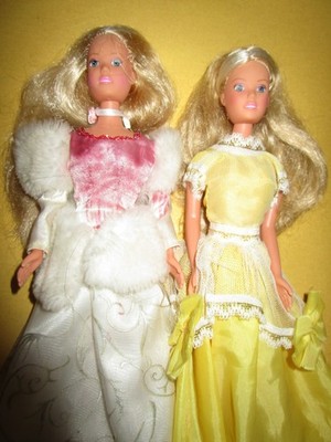 B710) ZWEI ALTE BLONDE SIMBA DOLL TOYS IN FESTLICHEN KLEIDERN BEIDE GUT ERHALTEN