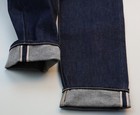 Dark blue denim AG Adriano Goldschmied men’s jeans with light gray trim and made in USA Cone Mill Selvedge label.