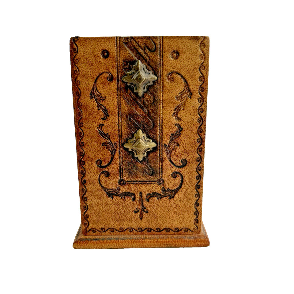A small Italian embossed leather pen holder with ornate tooled detailing — the kind of desk piece that screams old-world craft.